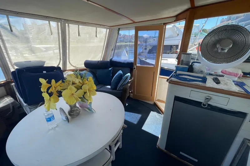 Slide: The Image of 1969 Chris-Craft 47 Commander interior with table, chairs, and decorative flowers. - 14