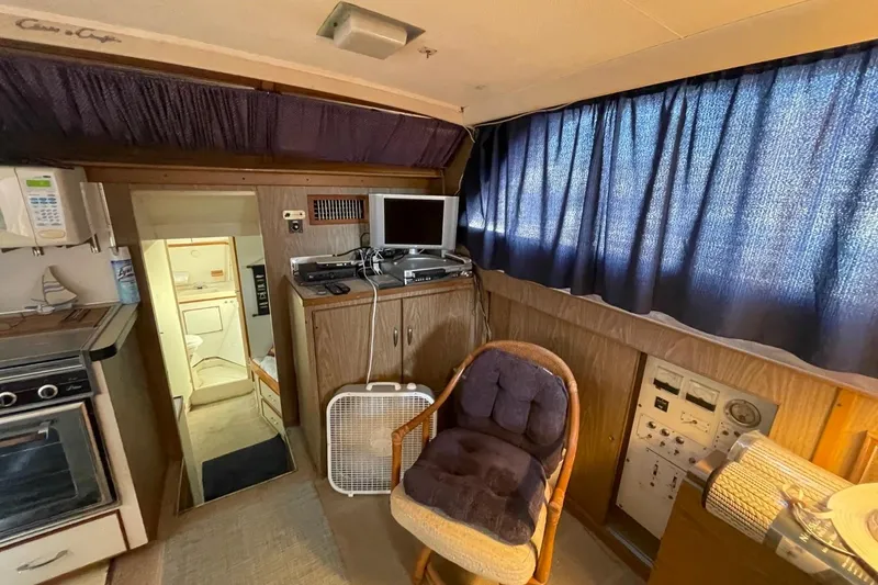 Slide: The Image of 1969 Chris-Craft 47 Commander interior with wood paneling, appliances, and seating. - 16