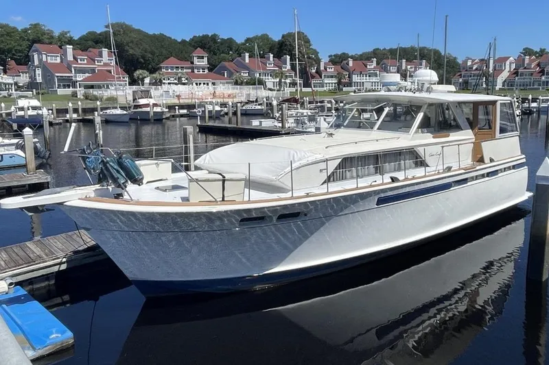 Slide: The Image of 1969 Chris-Craft 47 Commander yacht docked in a marina, surrounded by waterfront homes. - 2