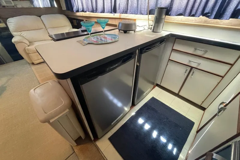 Slide: The Image of 1969 Chris-Craft 47 Commander interior with kitchen area, featuring appliances and seating. - 22
