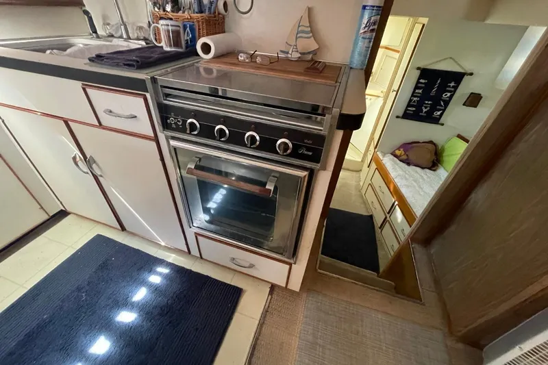 Slide: The Image of 1969 Chris-Craft 47 Commander kitchen with stove, sink, and cozy cabin view. - 23