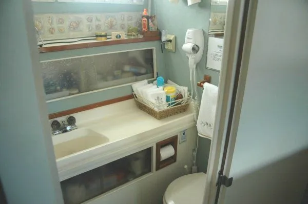 Slide: The Image of 1969 Chris-Craft 47 Commander bathroom with sink, mirror, and toiletries. - 25