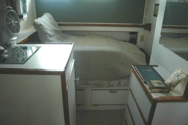 Slide: The Image of 1969 Chris-Craft 47 Commander cabin interior with bed, fan, and storage drawers. - 27