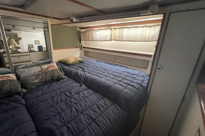 Slide: The Image of Cozy bedroom interior of 1969 Chris-Craft 47 Commander yacht with blue bedding and pillows. - 32