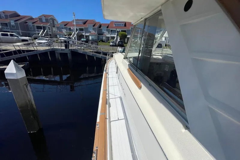 Slide: The Image of 1969 Chris-Craft 47 Commander docked at marina, showcasing sleek design and waterfront homes. - 46
