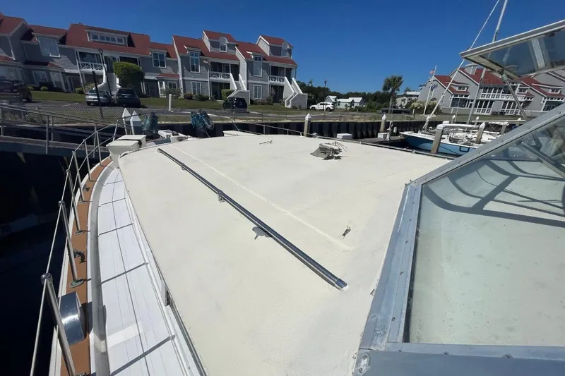 Slide: The Image of 1969 Chris-Craft 47 Commander docked near waterfront homes under clear blue sky. - 47