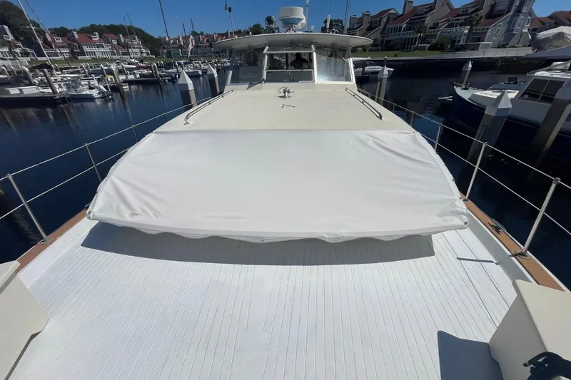 Slide: The Image of 1969 Chris-Craft 47 Commander yacht docked at a marina, showcasing spacious deck. - 50