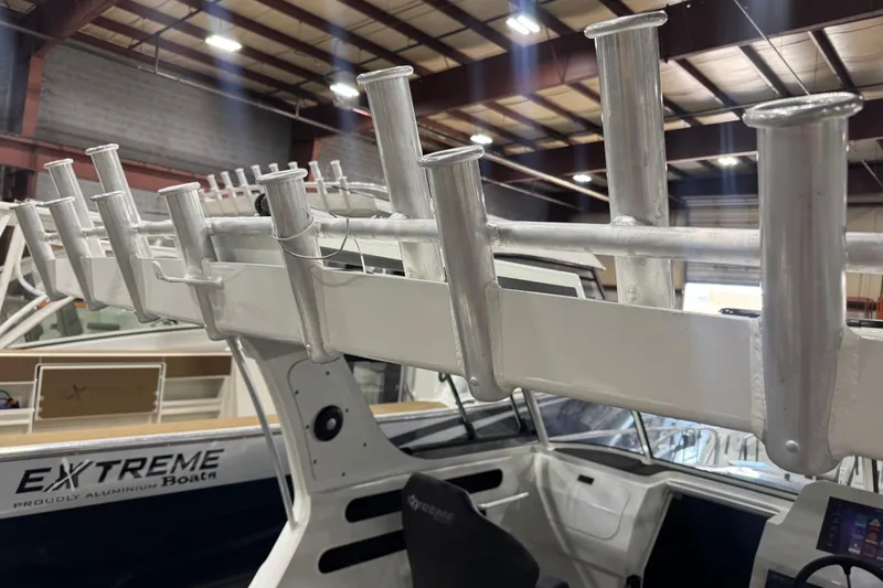 Slide: The Image of 2026 Extreme Boats 696 Game King interior with rod holders in a showroom. - 16