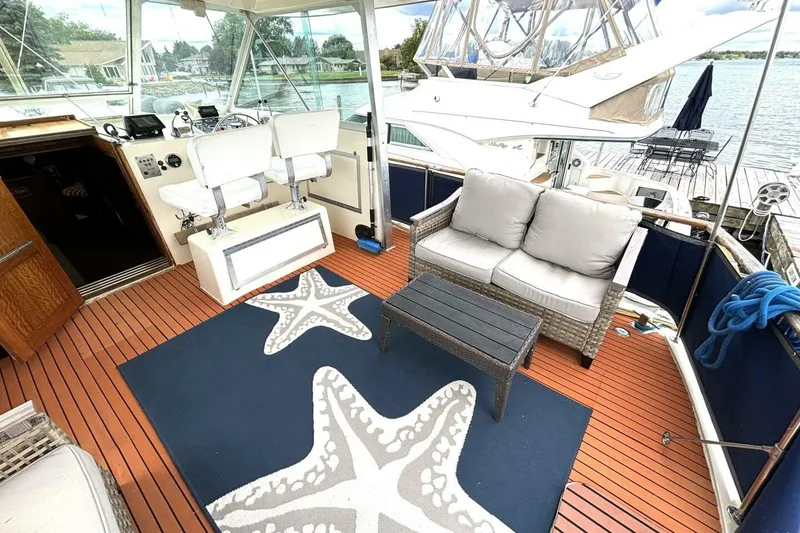Slide: The Image of 1972 Hatteras 43DC yacht deck with seating, starfish rug, and helm chairs. - 10