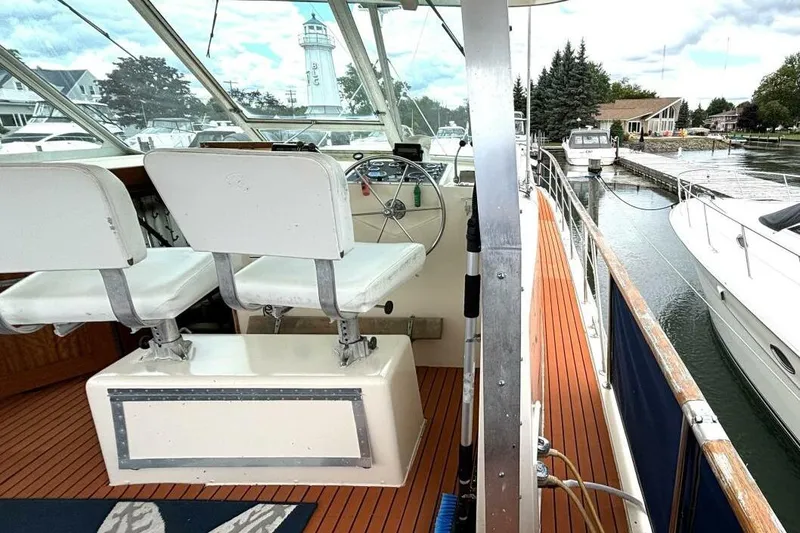 Slide: The Image of 1972 Hatteras 43DC yacht interior with helm, white seats, and marina view. - 12
