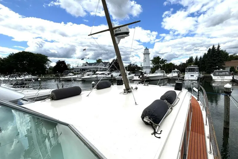 Slide: The Image of 1972 Hatteras 43DC yacht docked at a marina with a lighthouse in the background. - 14