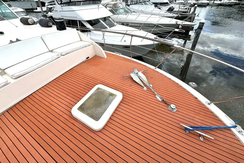 Slide: The Image of 1972 Hatteras 43DC yacht deck with seating, docked among other boats. - 16