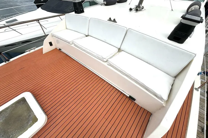 Slide: The Image of 1972 Hatteras 43DC yacht with white cushioned seating on teak deck. - 18