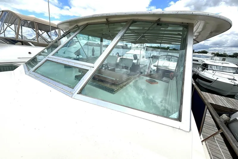 Slide: The Image of 1972 Hatteras 43DC yacht with large windows, docked among other boats. - 19