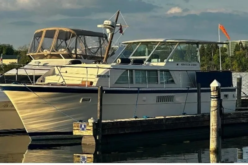 Slide: The Image of 1972 Hatteras 43DC yacht docked at marina, featuring classic design and spacious deck. - 3