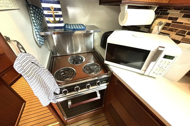 Slide: The Image of 1972 Hatteras 43DC yacht kitchen with stove, microwave, and nautical decor. - 32