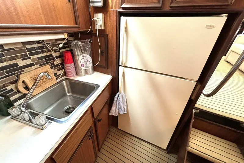 Slide: The Image of 1972 Hatteras 43DC yacht kitchen with sink, fridge, and wooden cabinetry. - 33