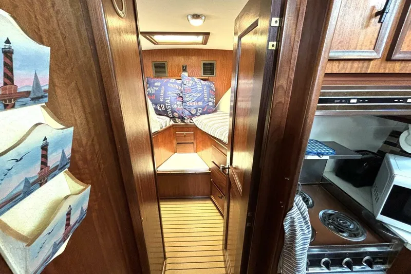 Slide: The Image of 1972 Hatteras 43DC interior with cozy cabin, wooden finishes, and compact kitchen area. - 34
