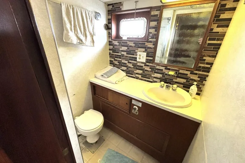 Slide: The Image of Bathroom interior of 1972 Hatteras 43DC yacht with sink, toilet, and mirror. - 40