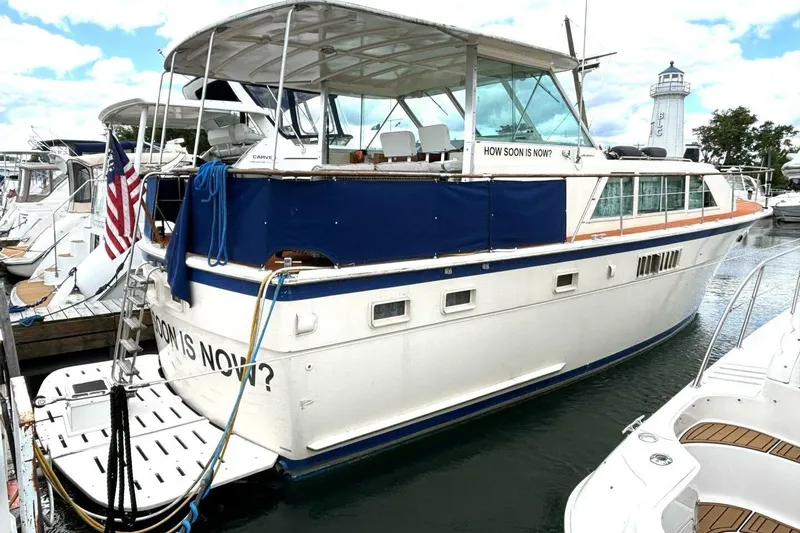 Slide: The Image of 1972 Hatteras 43DC yacht docked, featuring blue accents and an American flag. - 7