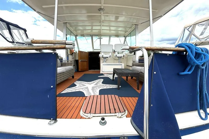 Slide: The Image of 1972 Hatteras 43DC yacht deck with seating, starfish rug, and blue accents. - 8