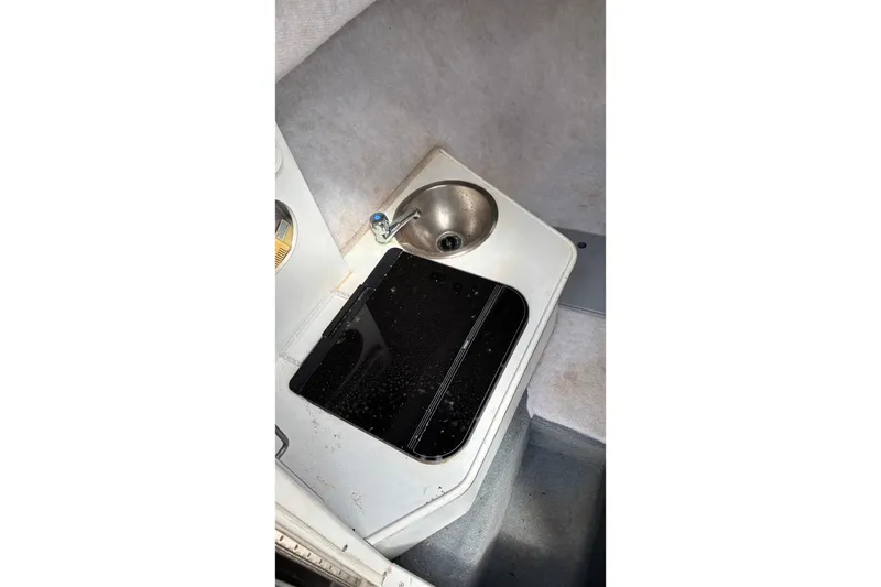 Slide: The Image of 2002 Wellcraft 24 Walkaround boat interior with sink and stove. - 10