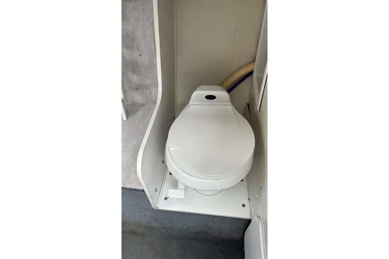 Slide: The Image of 2002 Wellcraft 24 Walkaround boat interior with compact marine toilet. - 11