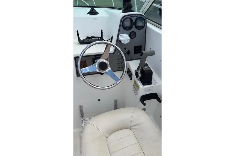 Slide: The Image of 2002 Wellcraft 24 Walkaround boat cockpit with steering wheel and controls. - 6