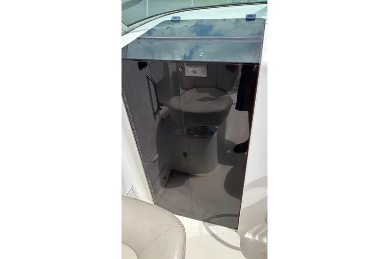 Slide: The Image of 2002 Wellcraft 24 Walkaround boat interior with a compact cabin toilet. - 7