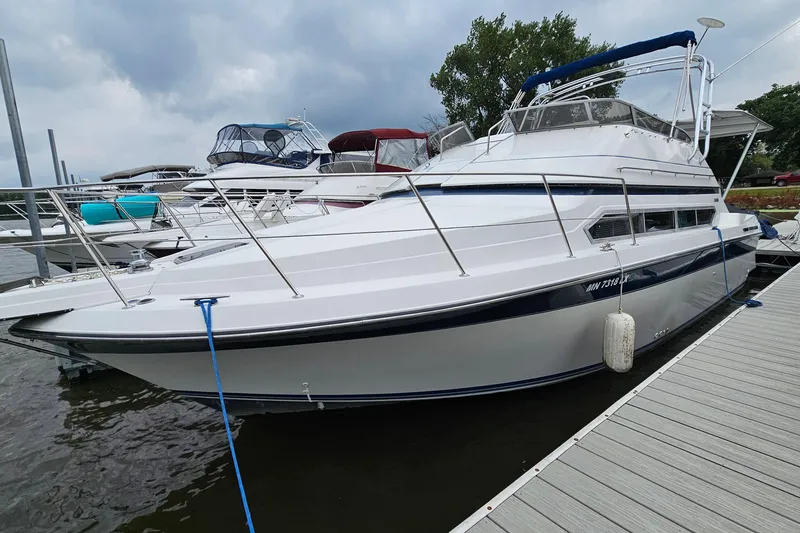 The Image of 1990 Carver 3467 Santego yacht docked at marina under cloudy sky. - 1