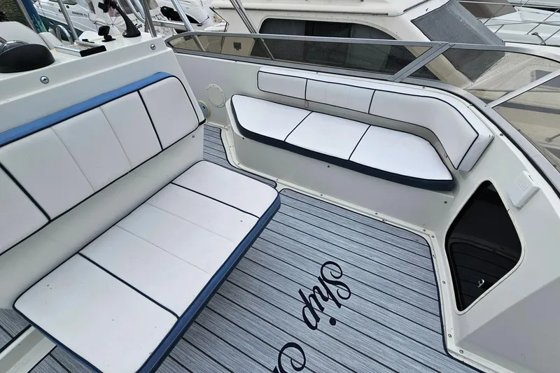 Slide: The Image of 1990 Carver 3467 Santego boat interior with white seating and striped flooring. - 12
