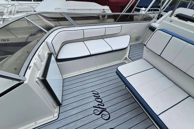 Slide: The Image of 1990 Carver 3467 Santego boat interior with white seating and striped flooring. - 13