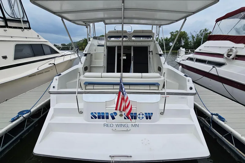 Slide: The Image of 1990 Carver 3467 Santego boat docked, displaying American flag, rear view. - 5