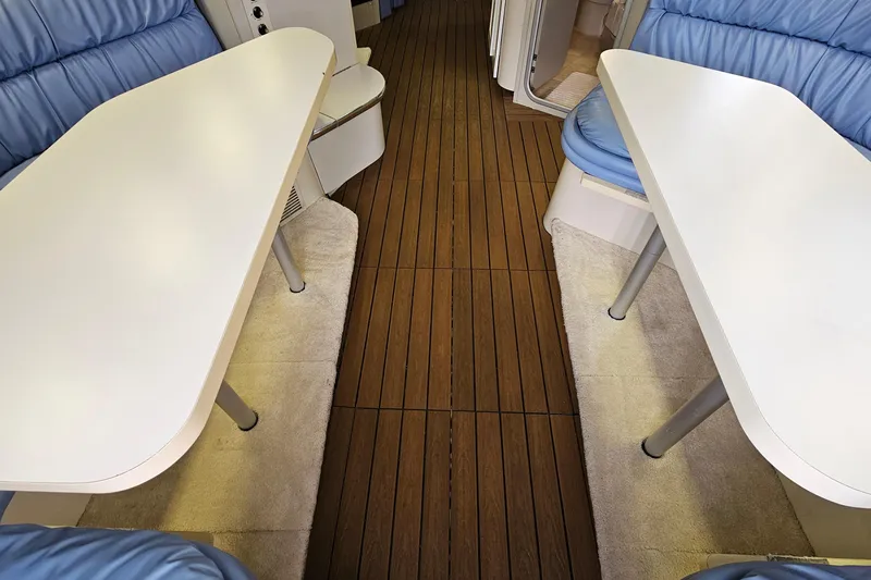 Slide: The Image of Interior of 1990 Carver 3467 Santego yacht with white tables and blue seating. - 29