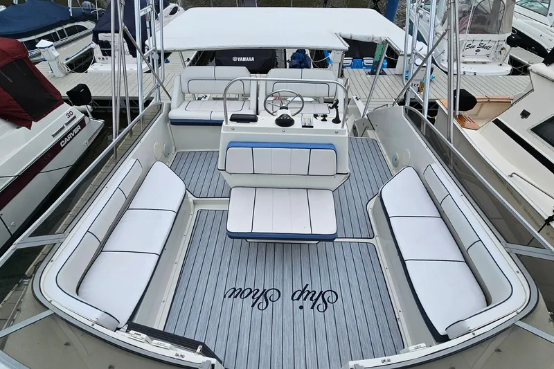 Slide: The Image of 1990 Carver 3467 Santego boat interior with white seating and steering console. - 8