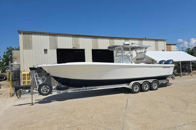 Slide: The Image of 2007 Competition 31 boat on trailer outside industrial building under clear blue sky. - 28