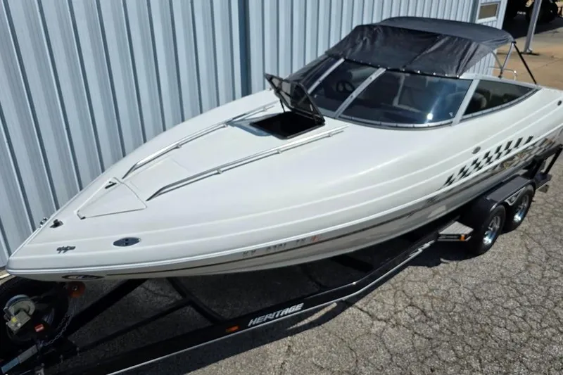 Slide: The Image of 1999 Mariah Shabah Z250 Cuddy Cabin boat on trailer, parked near metal building. - 15