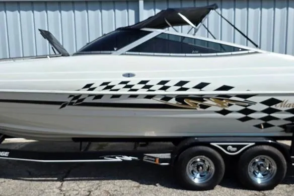 Slide: The Image of 1999 Mariah Shabah Z250 Cuddy Cabin boat with checkered graphics on a trailer. - 24