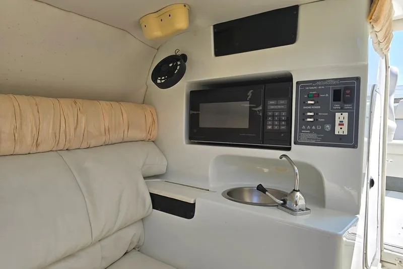 Slide: The Image of 1999 Mariah Shabah Z250 Cuddy Cabin interior with microwave, sink, and seating. - 9