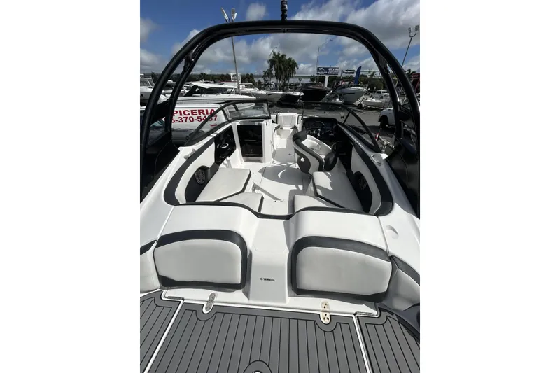 Slide: The Image of 2017 Yamaha Boats 212X interior with sleek seating and modern design under a clear sky. - 10