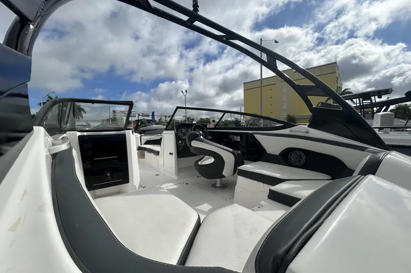 Slide: The Image of 2017 Yamaha Boats 212X interior with sleek seating and modern dashboard under a cloudy sky. - 5