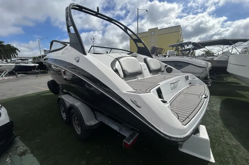 Slide: The Image of 2017 Yamaha Boats 212X on trailer, sleek design, parked outdoors under cloudy sky. - 9