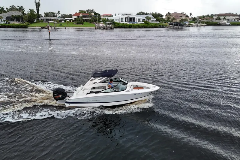 Slide: The Image of 2021 Regal LX2 boat cruising on a scenic waterway near luxury homes. - 10