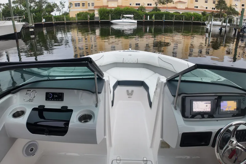 Slide: The Image of 2021 Regal LX2 boat interior with modern dashboard and waterfront view. - 11