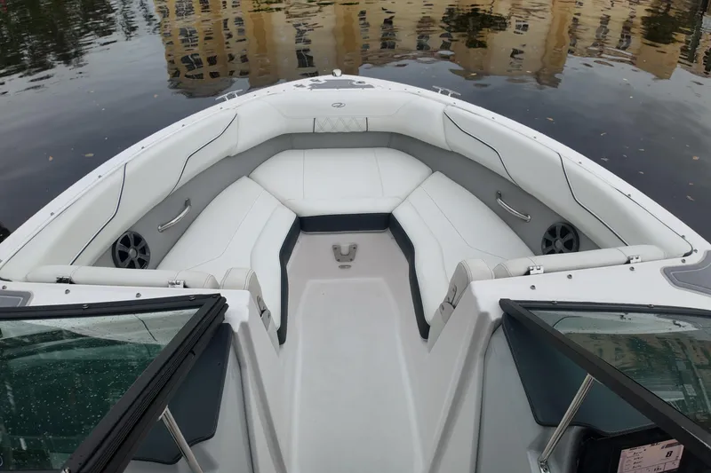 Slide: The Image of 2021 Regal LX2 boat interior with white seating and sleek design on calm water. - 13