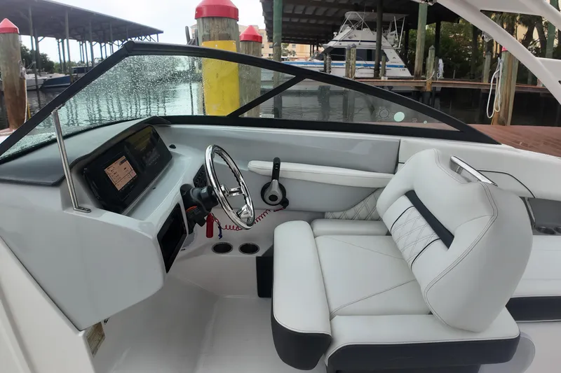 Slide: The Image of Interior of a 2021 Regal LX2 boat with sleek white seating and modern dashboard. - 19