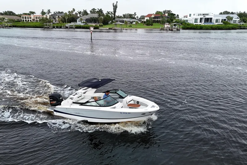 Slide: The Image of 2021 Regal LX2 boat cruising on a scenic river with waterfront homes in the background. - 23