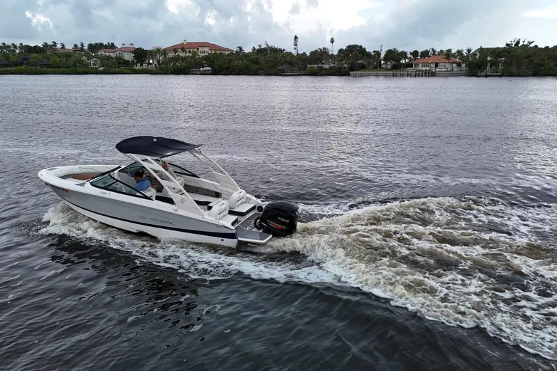 Slide: The Image of 2021 Regal LX2 boat cruising on a scenic river with lush greenery in the background. - 24