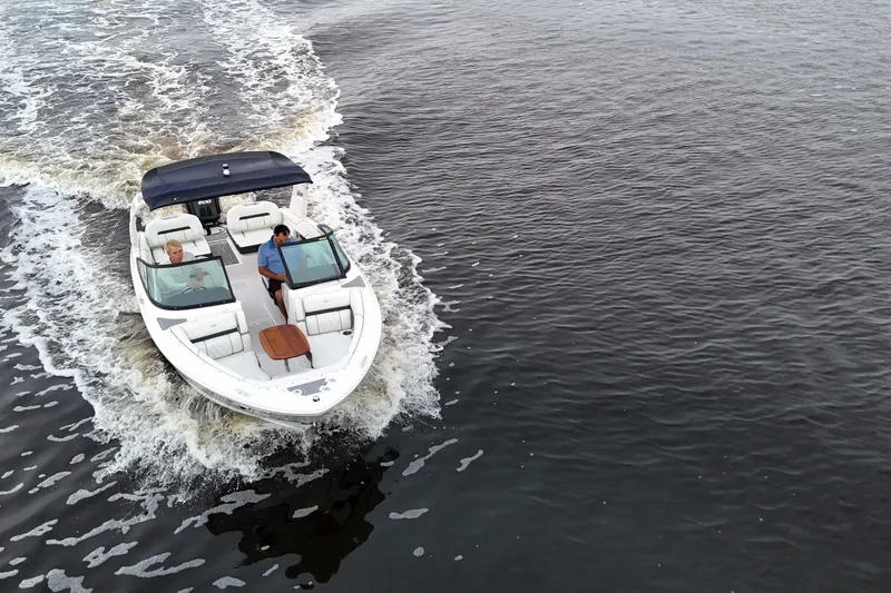 Slide: The Image of 2021 Regal LX2 boat cruising on open water, top view. - 25