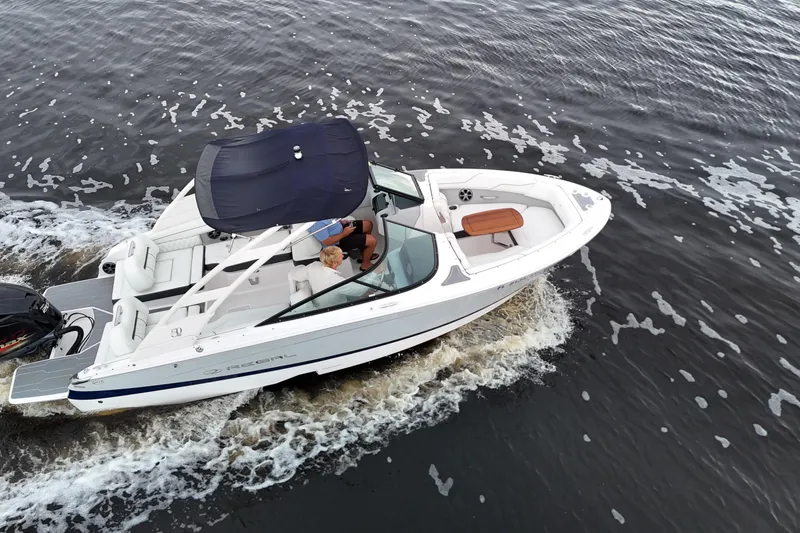 Slide: The Image of 2021 Regal LX2 boat cruising on water, featuring sleek design and spacious seating. - 9